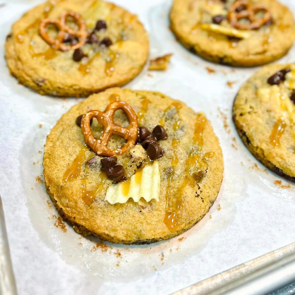 Four Poppy's Place cookies with pretzels, chocolate chips, caramel drizzle, and potato chips.